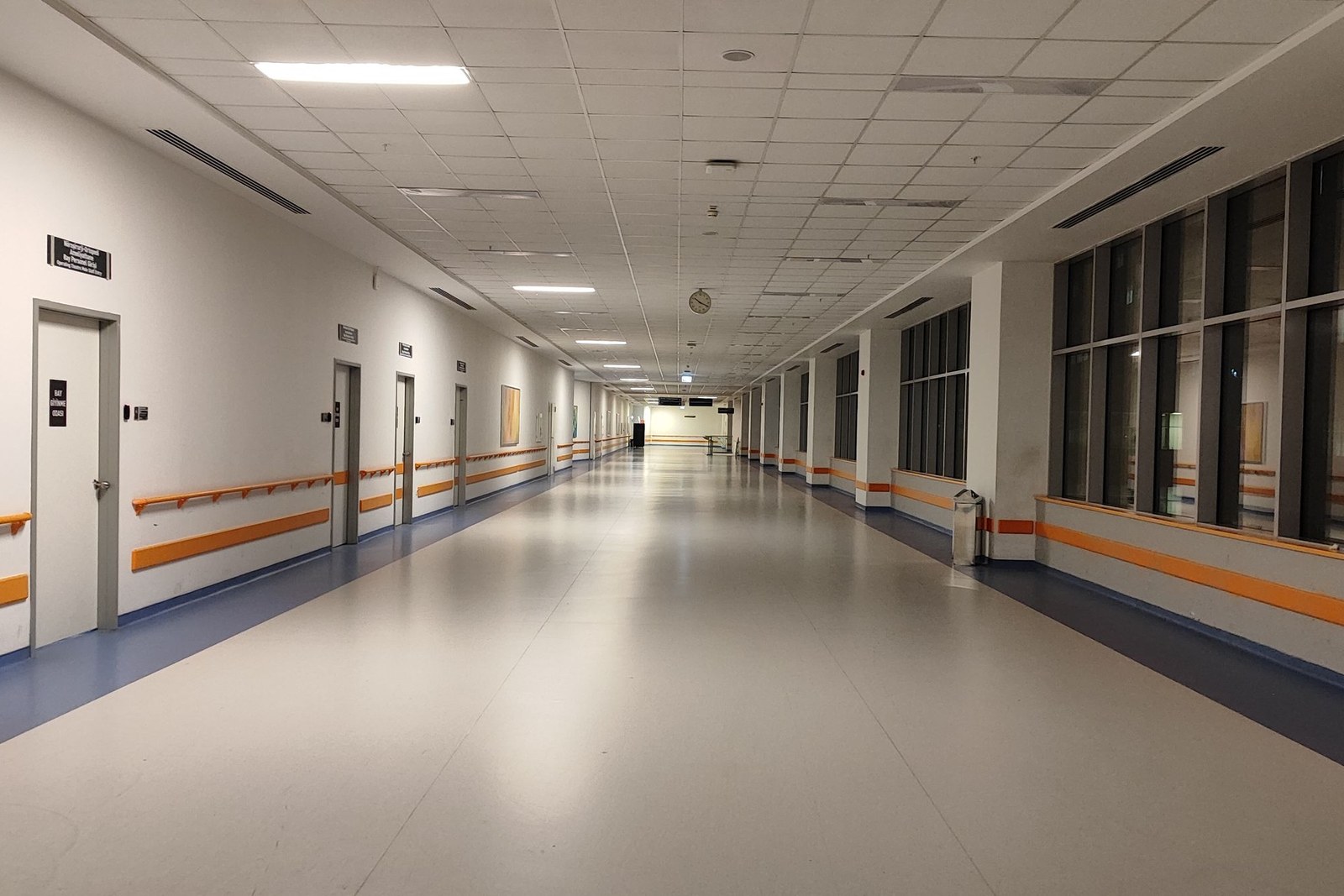 An empty clinical corridor running between departments in a medical facility